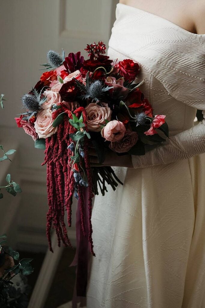 Amaranthus bridal bouquet with burgundy roses and thistles.