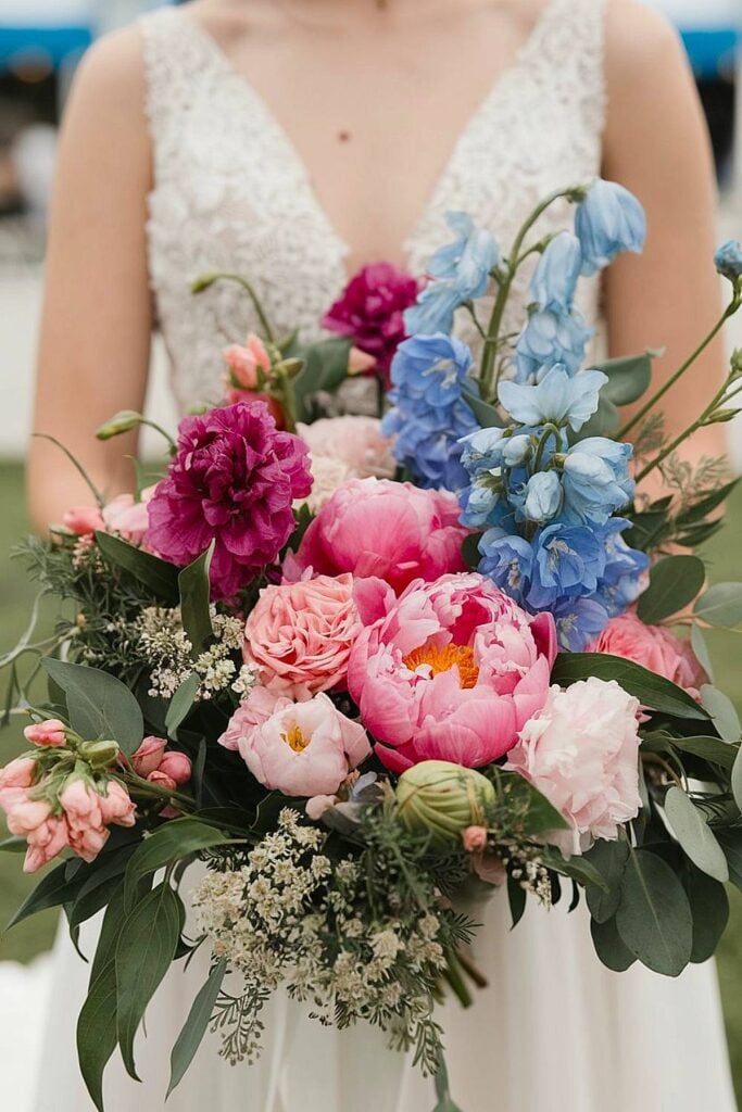 Blue and pink bridal bouquet with peonies and delphiniums.