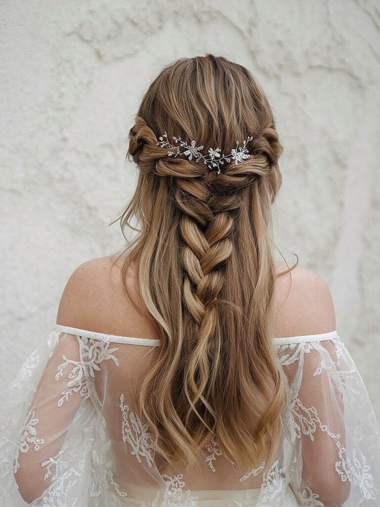Braided down bridal hairstyle with waves and floral clip