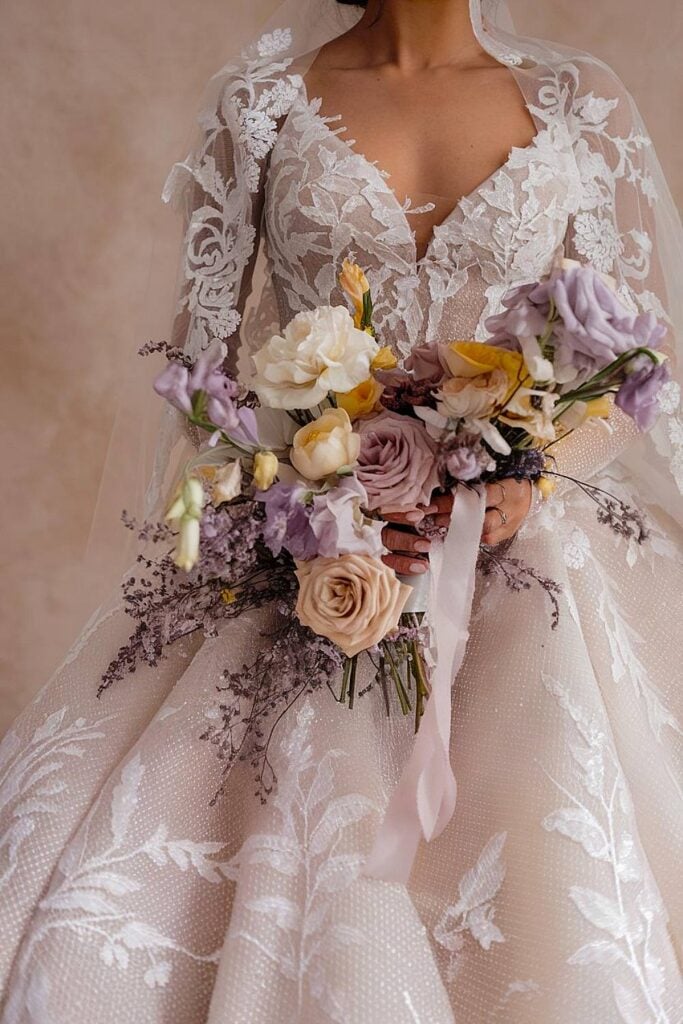 Spring bridal bouquet with lavender roses and soft yellow flowers.