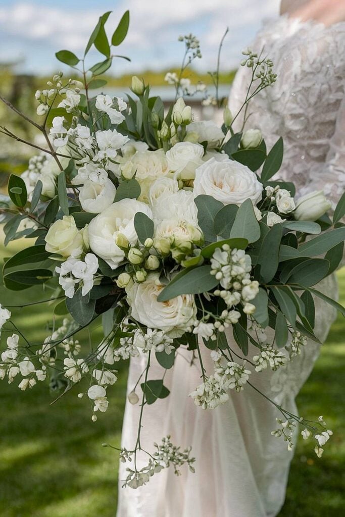 White bridal bouquet with roses and greenery.