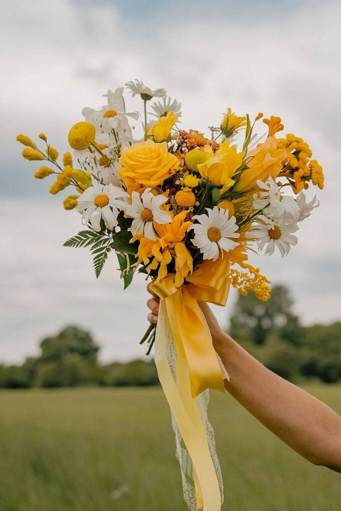 Yellow bridal bouquet with daisies and roses.