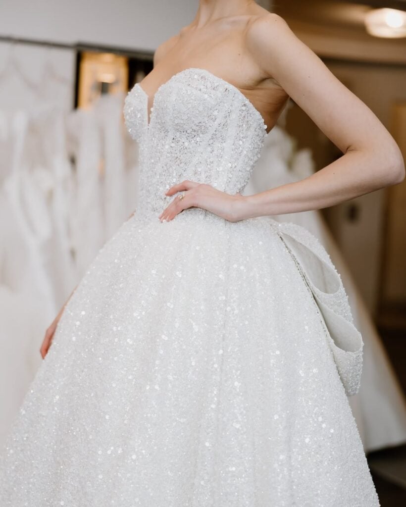 Designer luxury wedding dress with strapless beaded bodice and voluminous skirt.