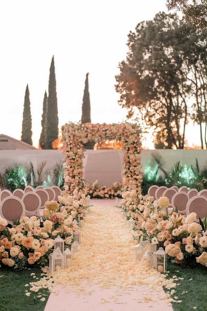 Rose petal aisle with blush floral decor for backyard wedding.