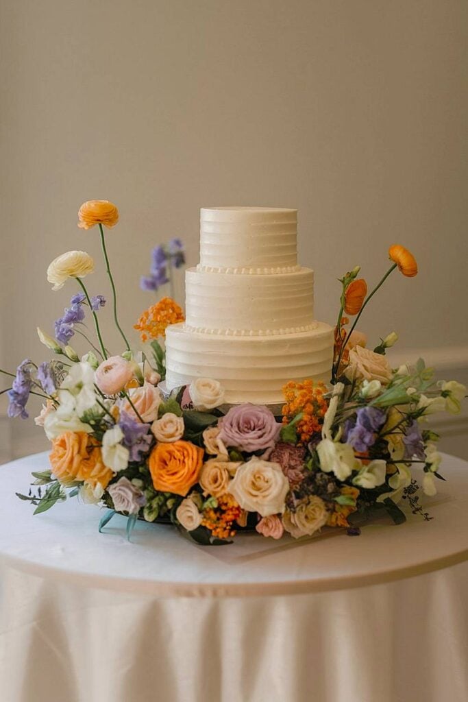 Flower meadow wedding cake with pastel blooms.