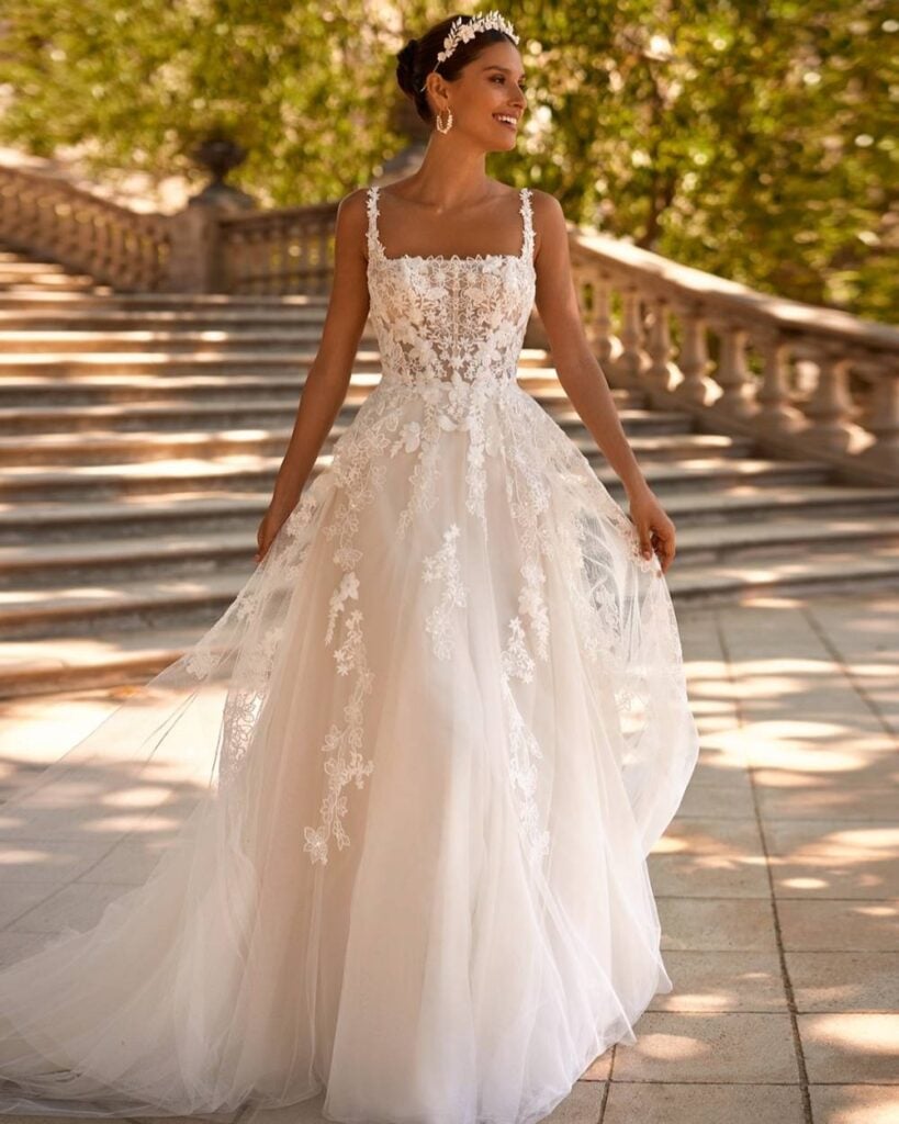 Flowing lace and tulle beach wedding gown with floral appliqué.