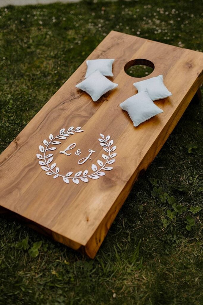 Custom wooden cornhole game with initials for backyard wedding.