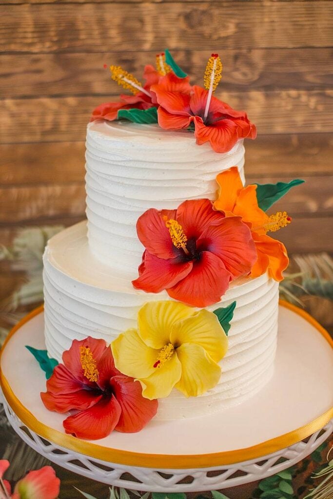 Hibiscus flower wedding cake with tropical colors.