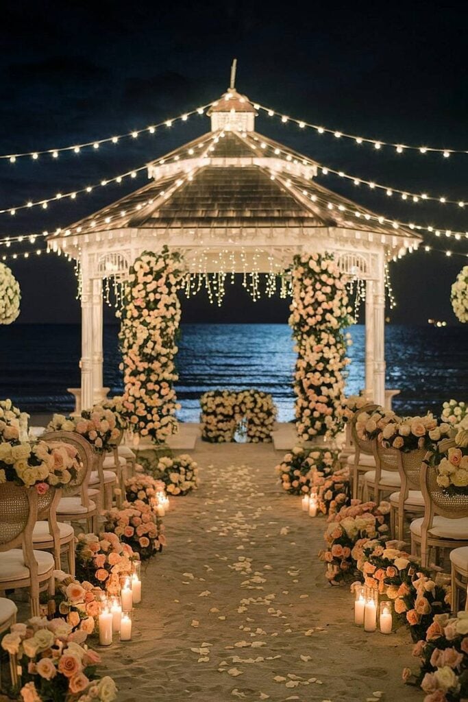 Romantic beach wedding altar setup with string lights and flowers.
