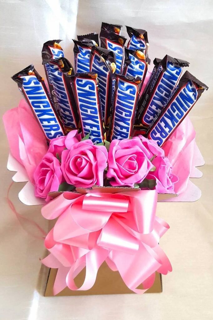 Snickers candy bouquet with pink flowers for weddings.