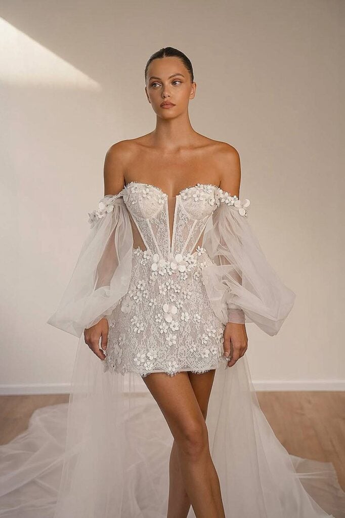 Corset boho wedding dress with floral appliqués and puff sleeves.