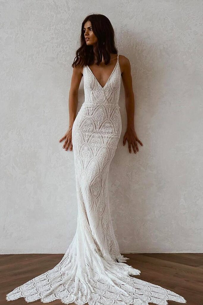 Fitted boho wedding dress with crochet lace and scalloped train.