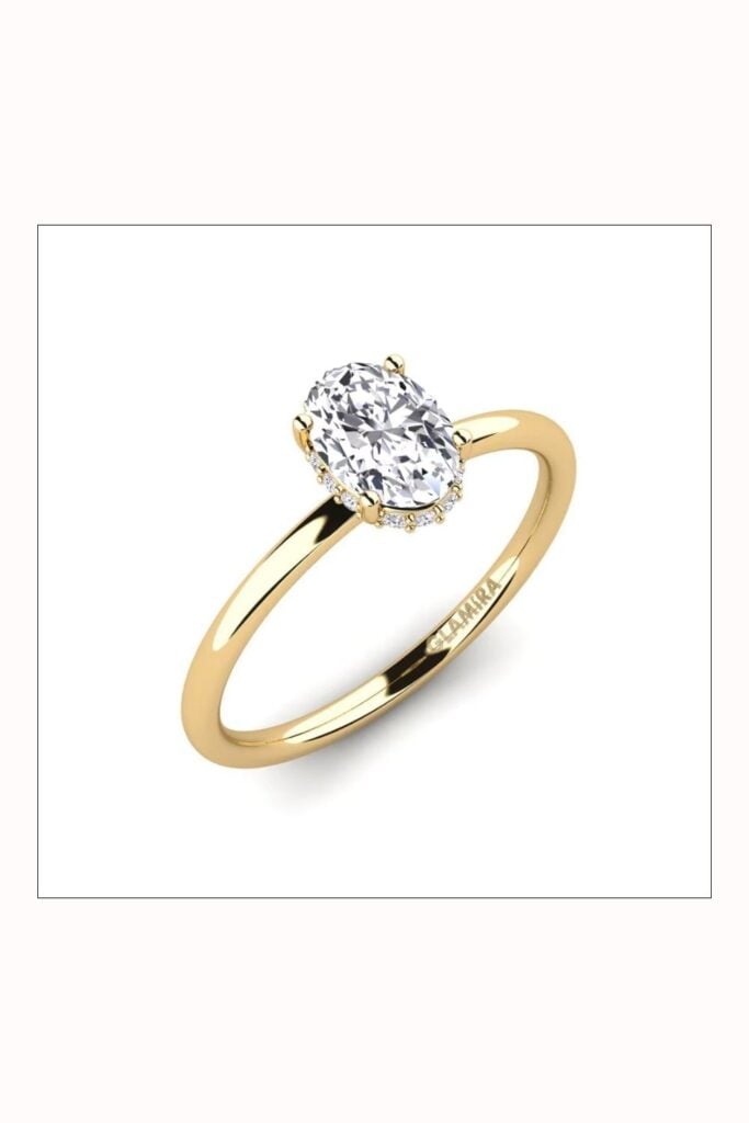 Gold oval engagement ring with diamond on yellow gold band.