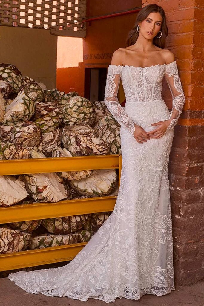 Off-shoulder boho wedding dress with long lace sleeves.