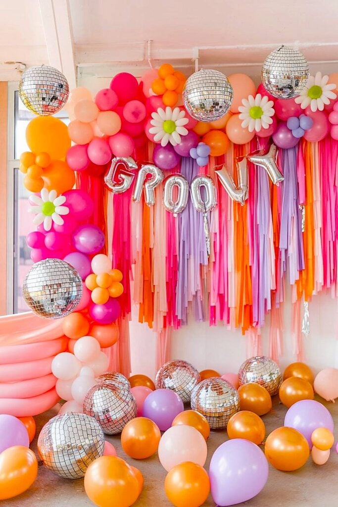 Retro bachelorette party with colorful balloons and disco balls.