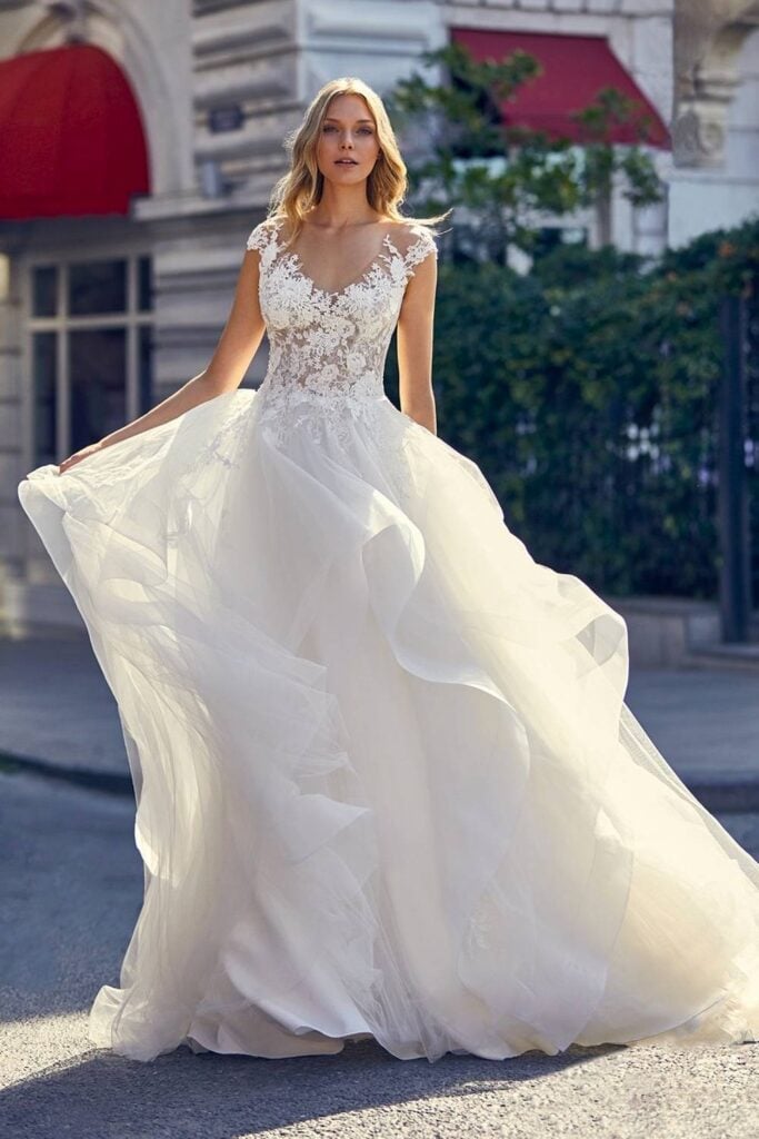 Ruffled fairytale wedding dress with lace bodice and flowing skirt.