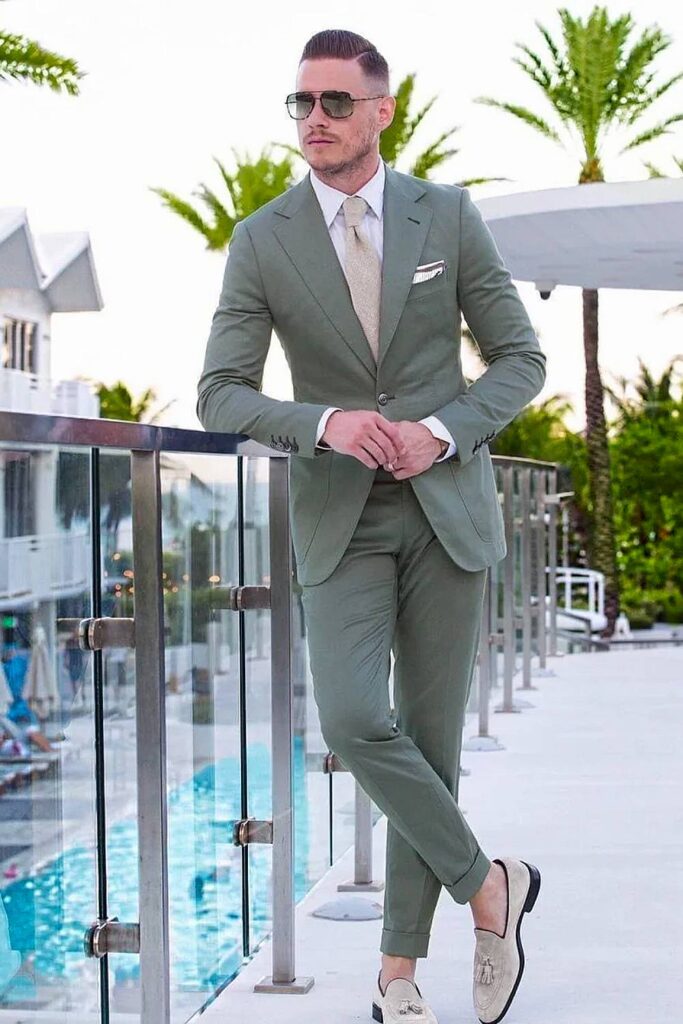 Sage green groomsmen suit outdoor wedding attire.