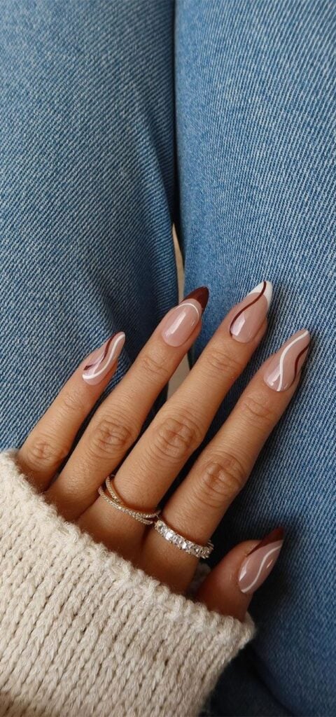 Neutral nude nails with white and cocoa-brown abstract swirl lines
