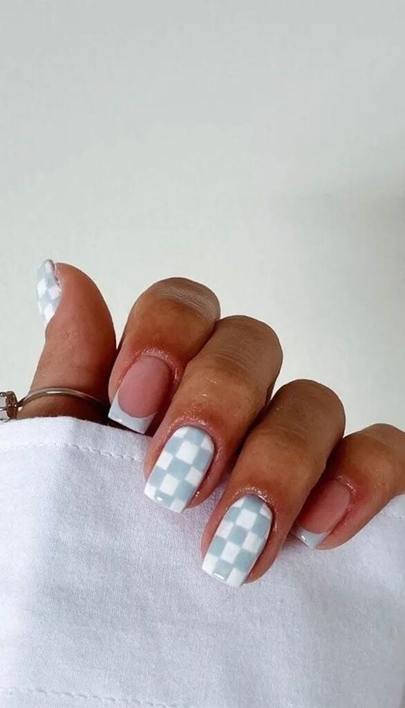 Short square nude nails with pale blue micro French tips and a light blue checker accent