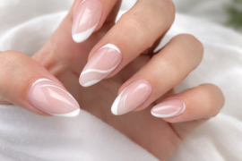 Sheer nude nails with white swooping French lines and negative-space curves