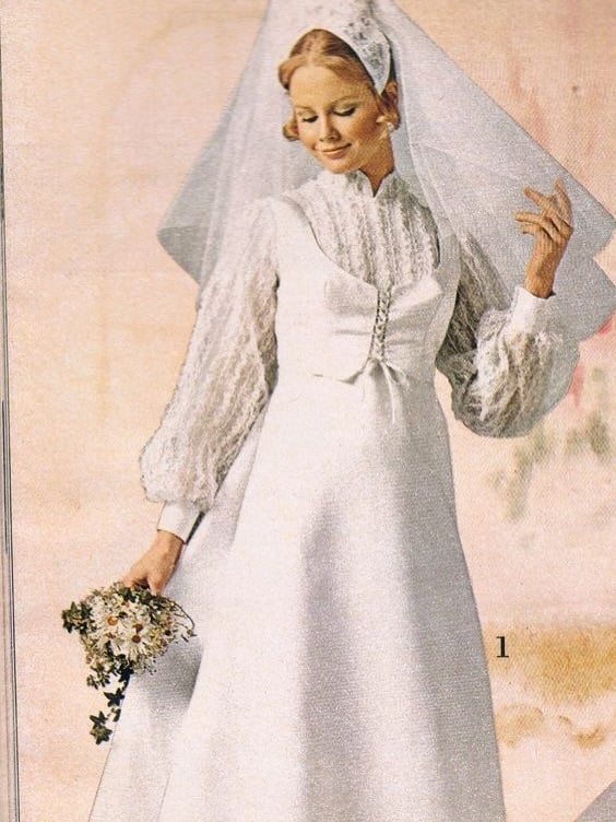 1970s bride in a satin A-line gown with bishop sleeves and a lace-up corset front