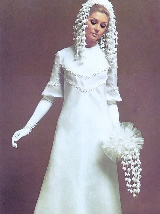 1970s bride with a cascading flower juliet cap headpiece and a trailing flower bouquet