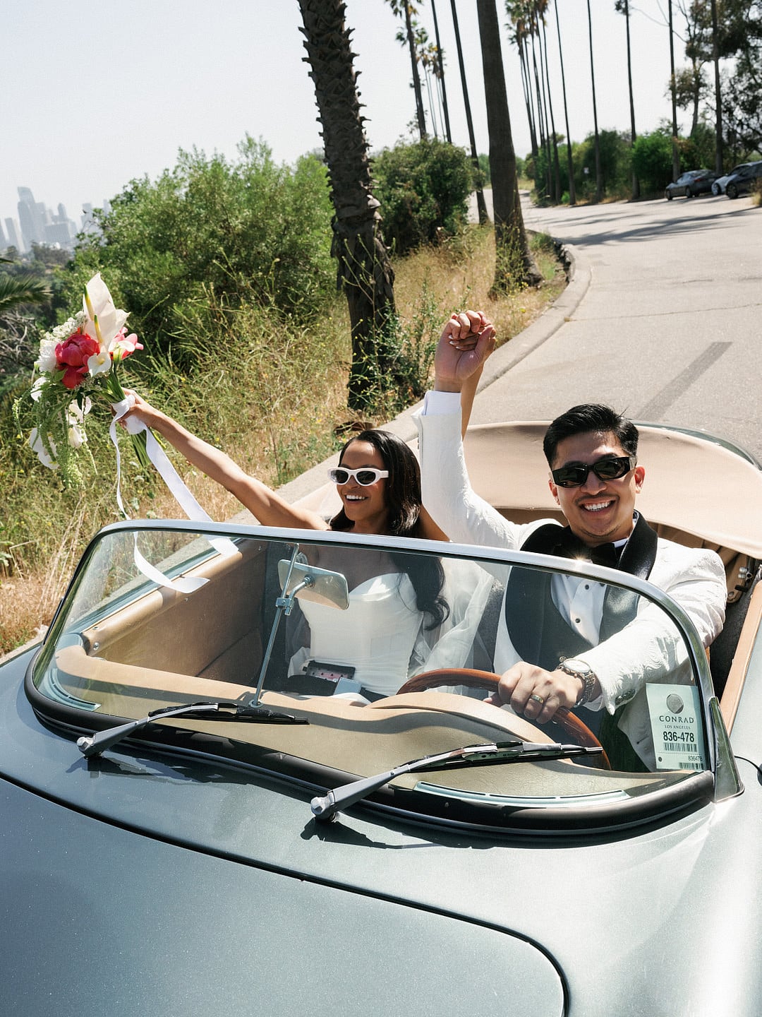 The bride in the convertible with her bouquet and sunglasses