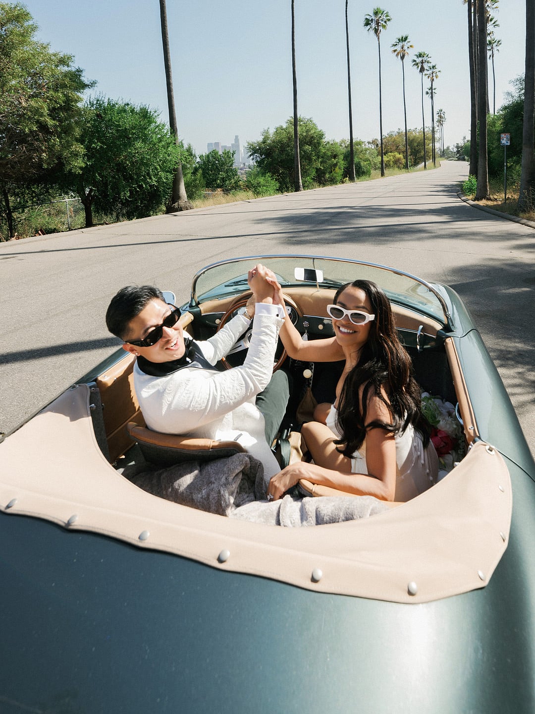 Dyeneka and Kevin high-fiving in the convertible