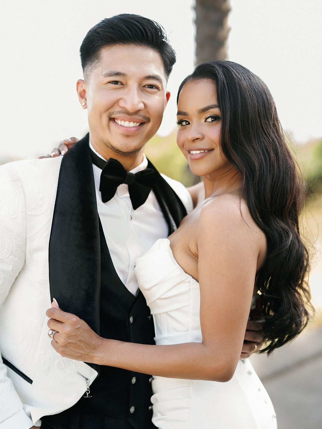 Dyeneka and Kevin's portrait, groom in a white tuxedo jacket