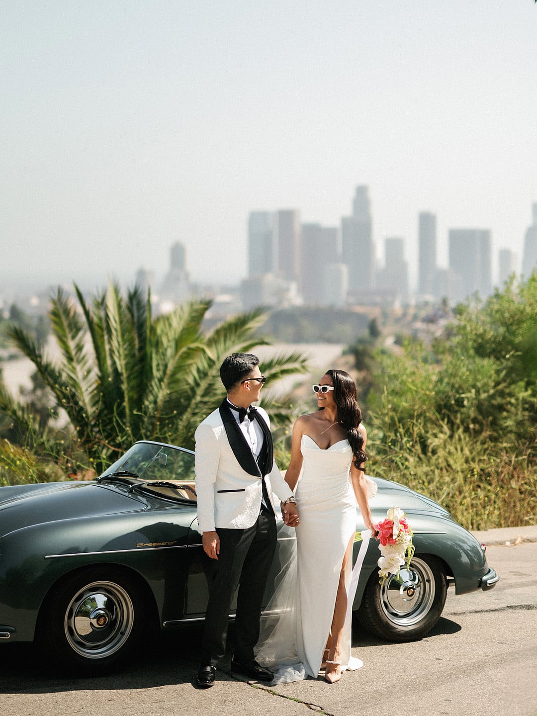 The couple standing by the Porsche with the full downtown skyline