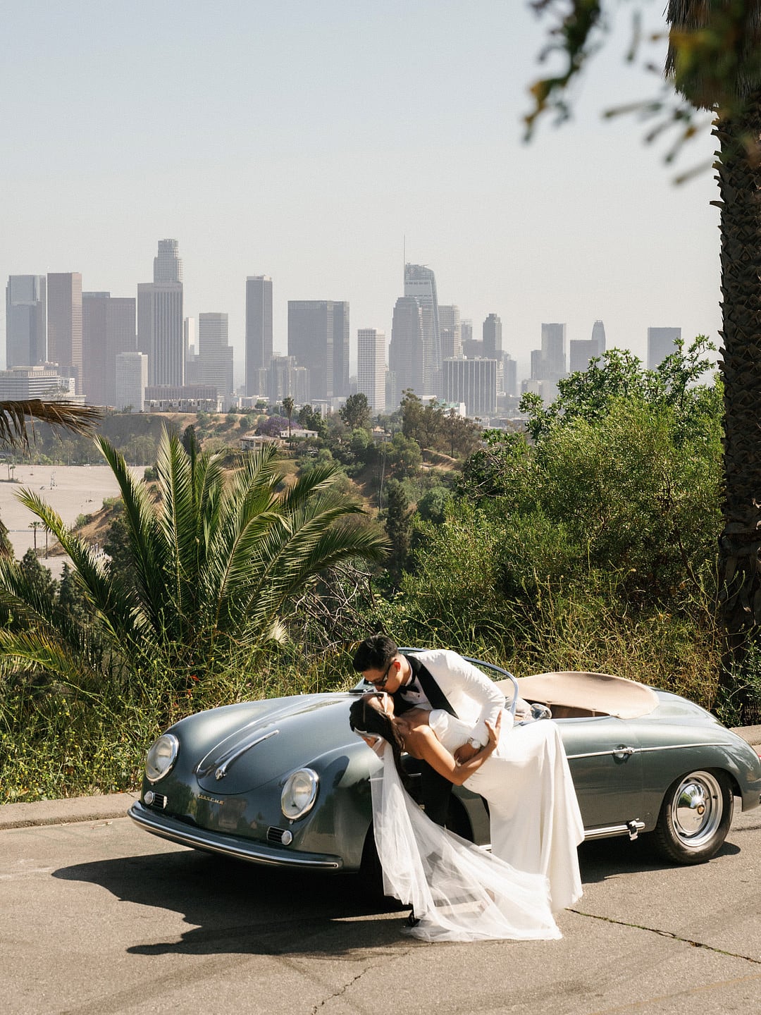 Dyeneka and Kevin kissing beside the car with the LA skyline