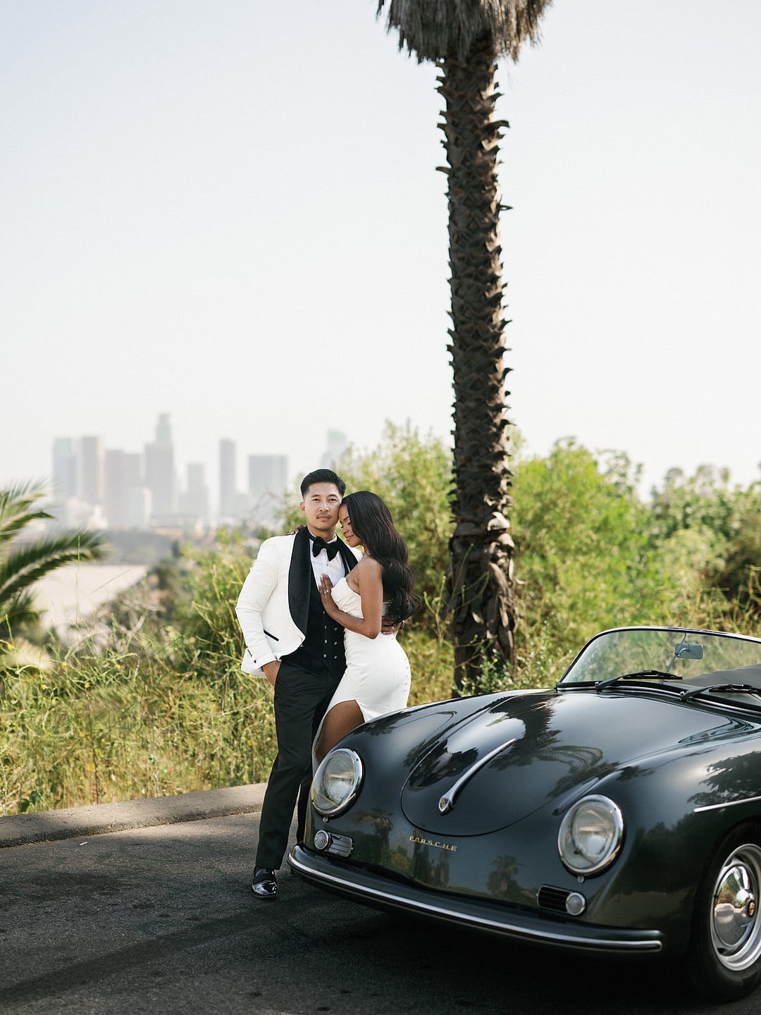 A kiss beside the car on a palm-lined Los Angeles street