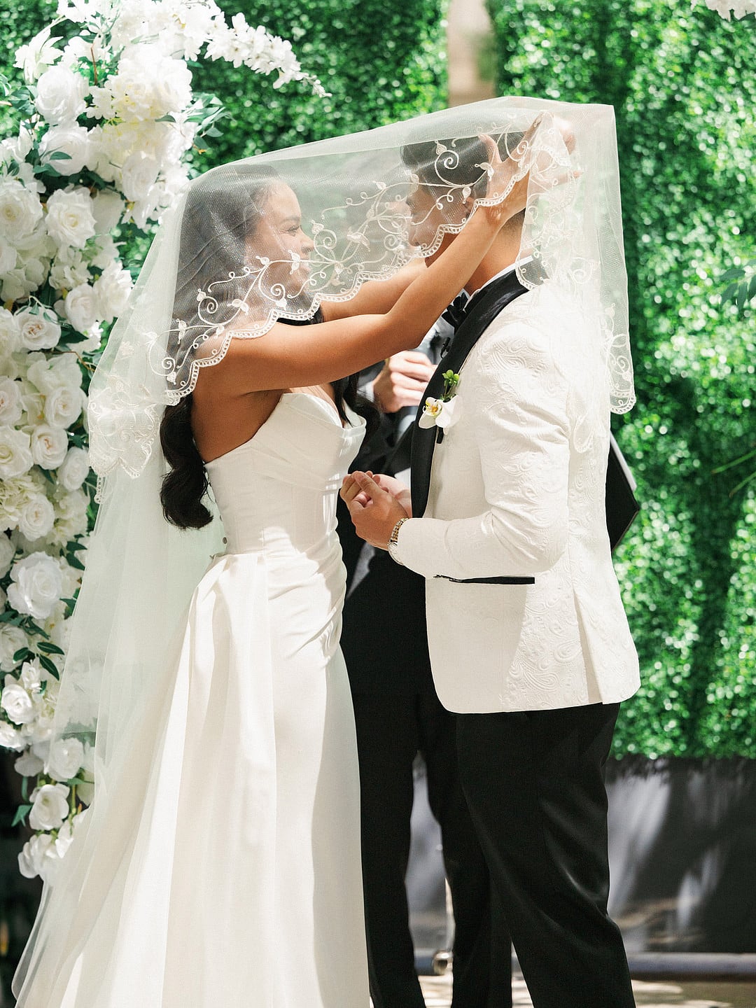 Rooftop wedding ceremony at a white floral arch in Los Angeles