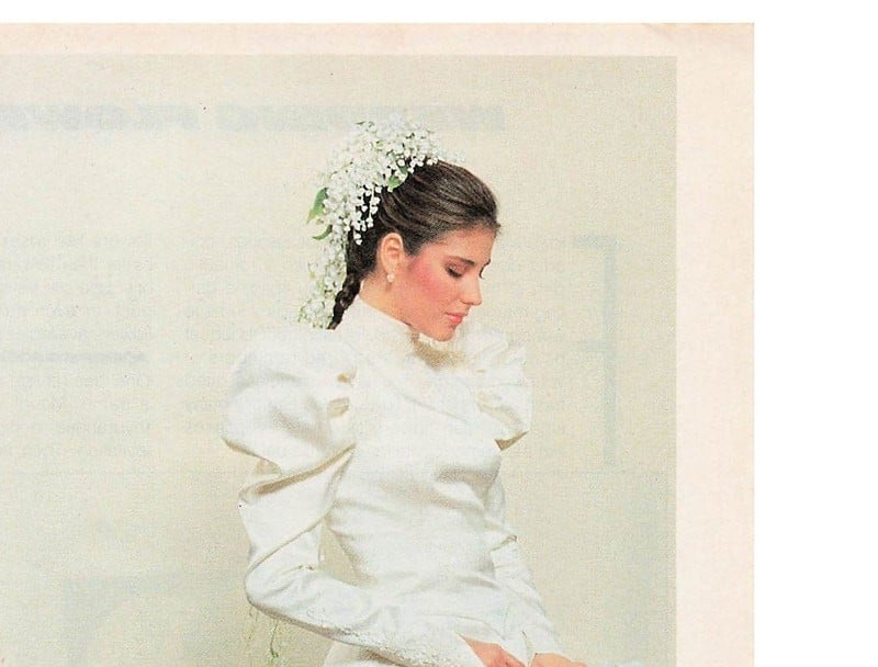 1982 Yumi Katsura ad from Bride's magazine, bride with sleek center-parted braid and cascading lily-of-the-valley hair comb