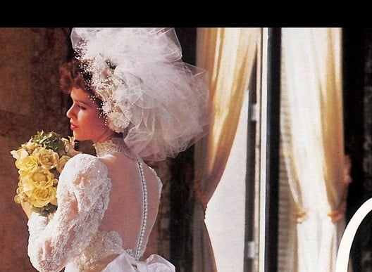 1988 Oscar de la Renta two-page wedding ad, one bride in a lace bow hat and one in a giant tulle pouf headpiece