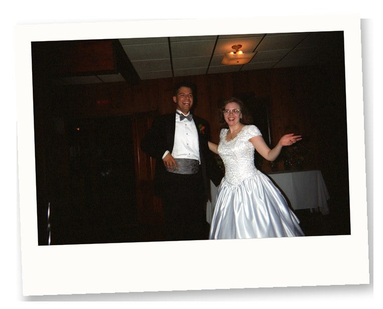 1990s bride and groom laughing at their wedding reception