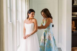 Quinn getting into her wedding dress with her mom in a floral gown