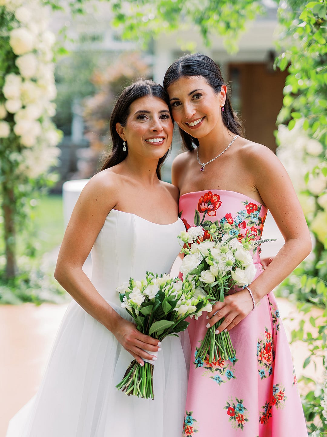 Quinn with her bridesmaids in pink floral dresses holding white bouquets