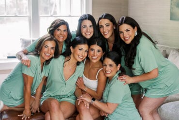 Quinn and her bridesmaids laughing together in green robes before the ceremony