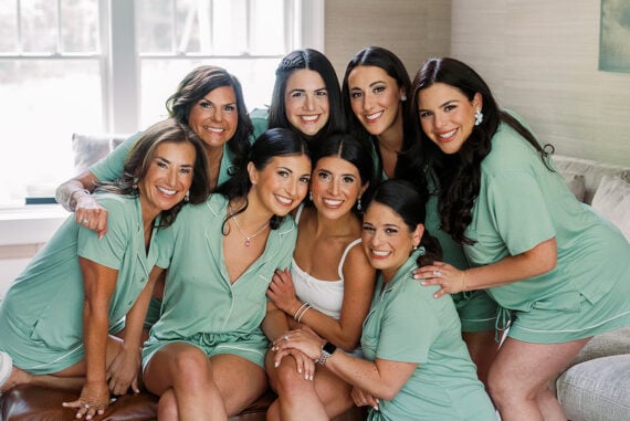 Quinn and her bridesmaids laughing together in green robes before the ceremony