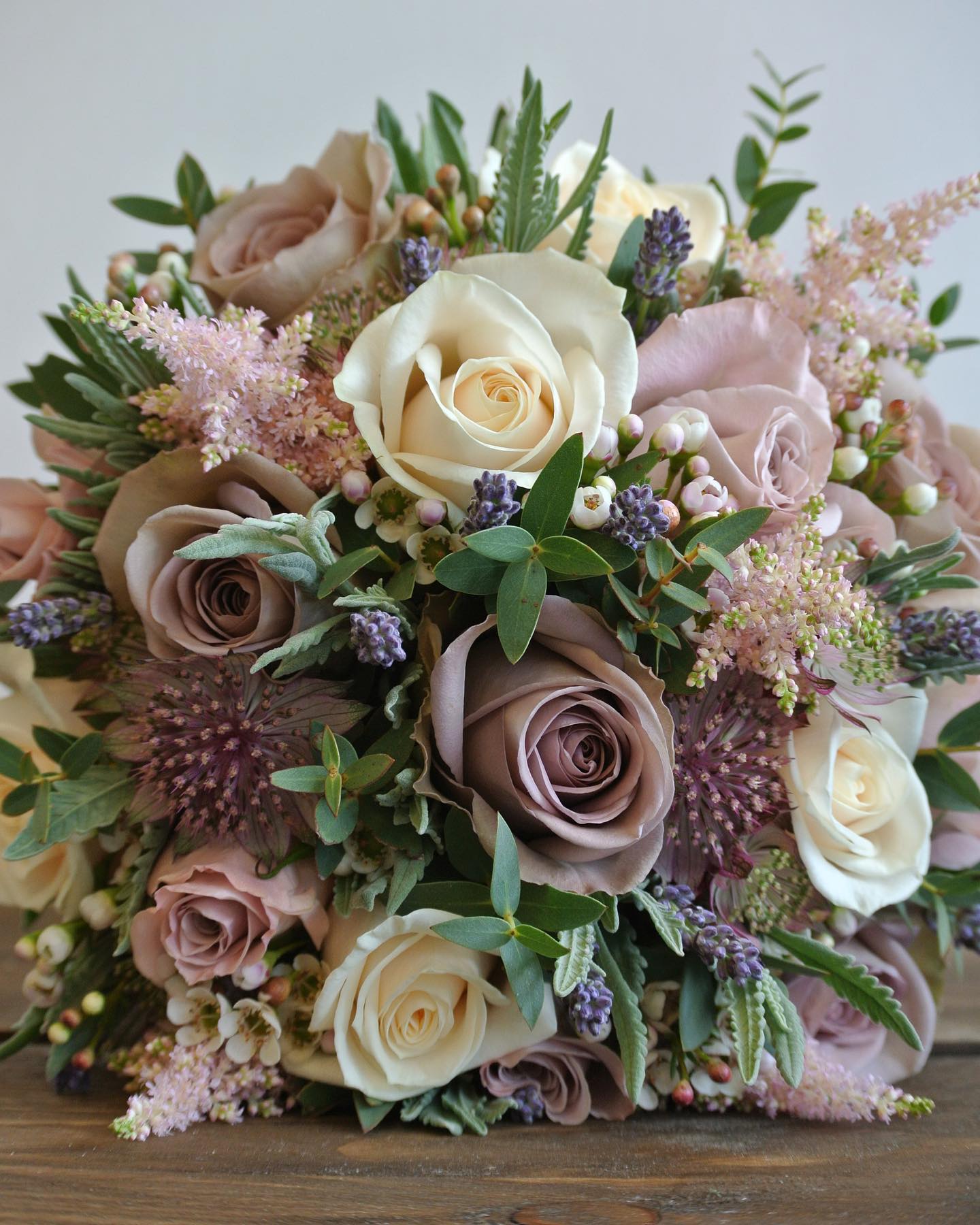 Rustic bridal bouquet with cream and dusty pink roses, lavender sprigs, waxflower and astilbe