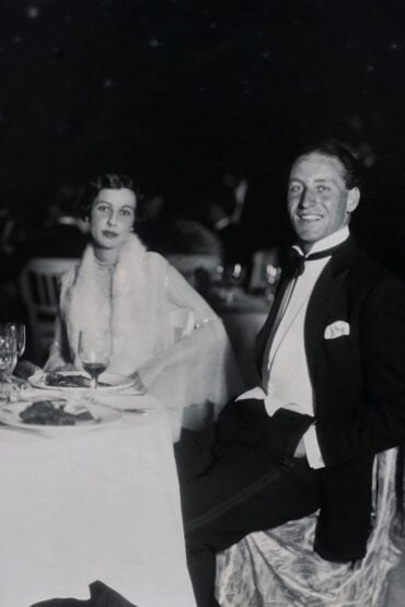 Vintage couple in formal attire seated at a wedding reception dinner table
