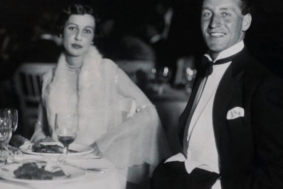 Vintage couple in formal attire seated at a wedding reception dinner table