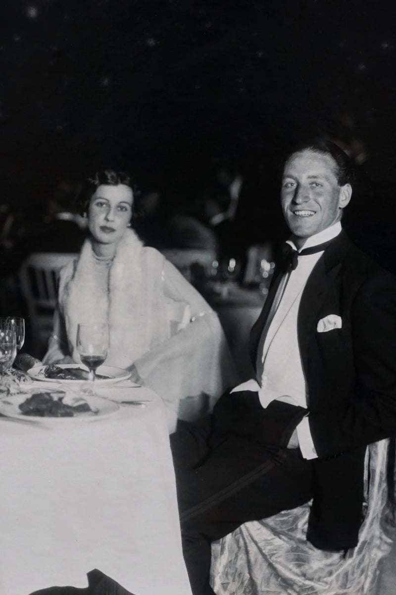 Vintage couple in formal attire seated at a wedding reception dinner table