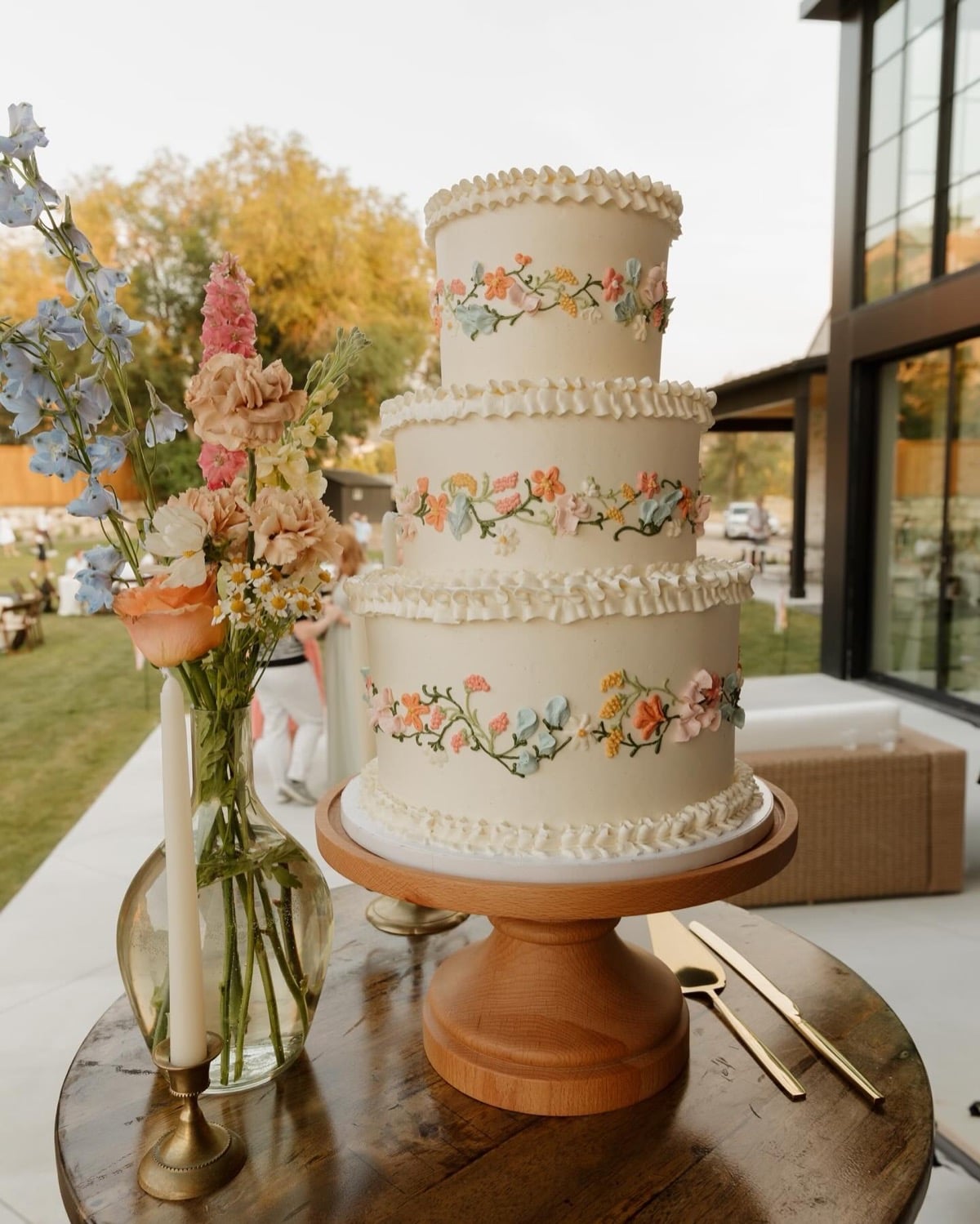 Vintage piped wedding cake with hand-piped wildflower garlands wrapping each tier