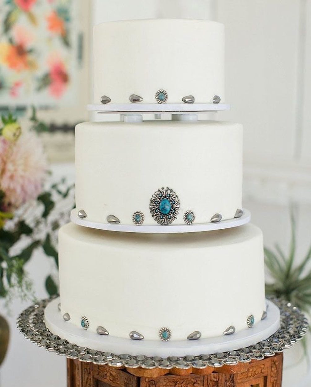 White wedding cake decorated with turquoise and silver concho details