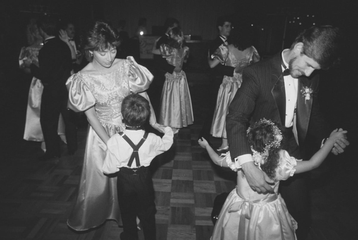 The groom dancing with the flower girl while a bridesmaid dances with the ring bearer, 1989