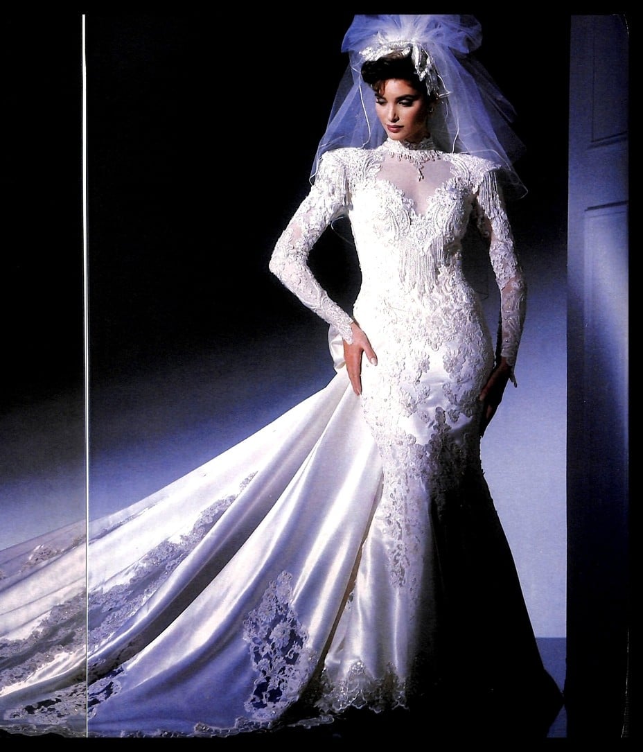 1988 Eve of Milady Ecstasies advertisement: bride in a long-sleeve lace mermaid wedding gown with a sheer neckline and a long satin train spread across the floor