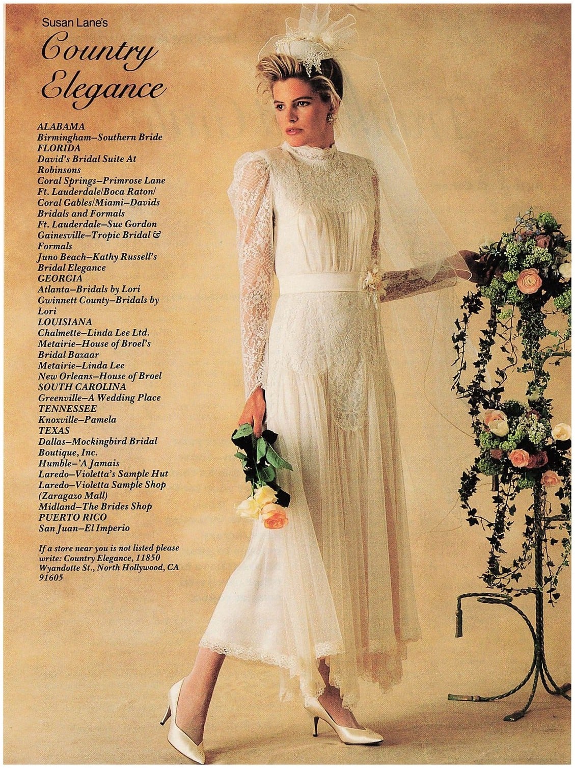 1987 Susan Lane's Country Elegance advertisement: bride in a tea-length lace wedding dress with a hi-lo hem, standing by a garden gate with a lace fan