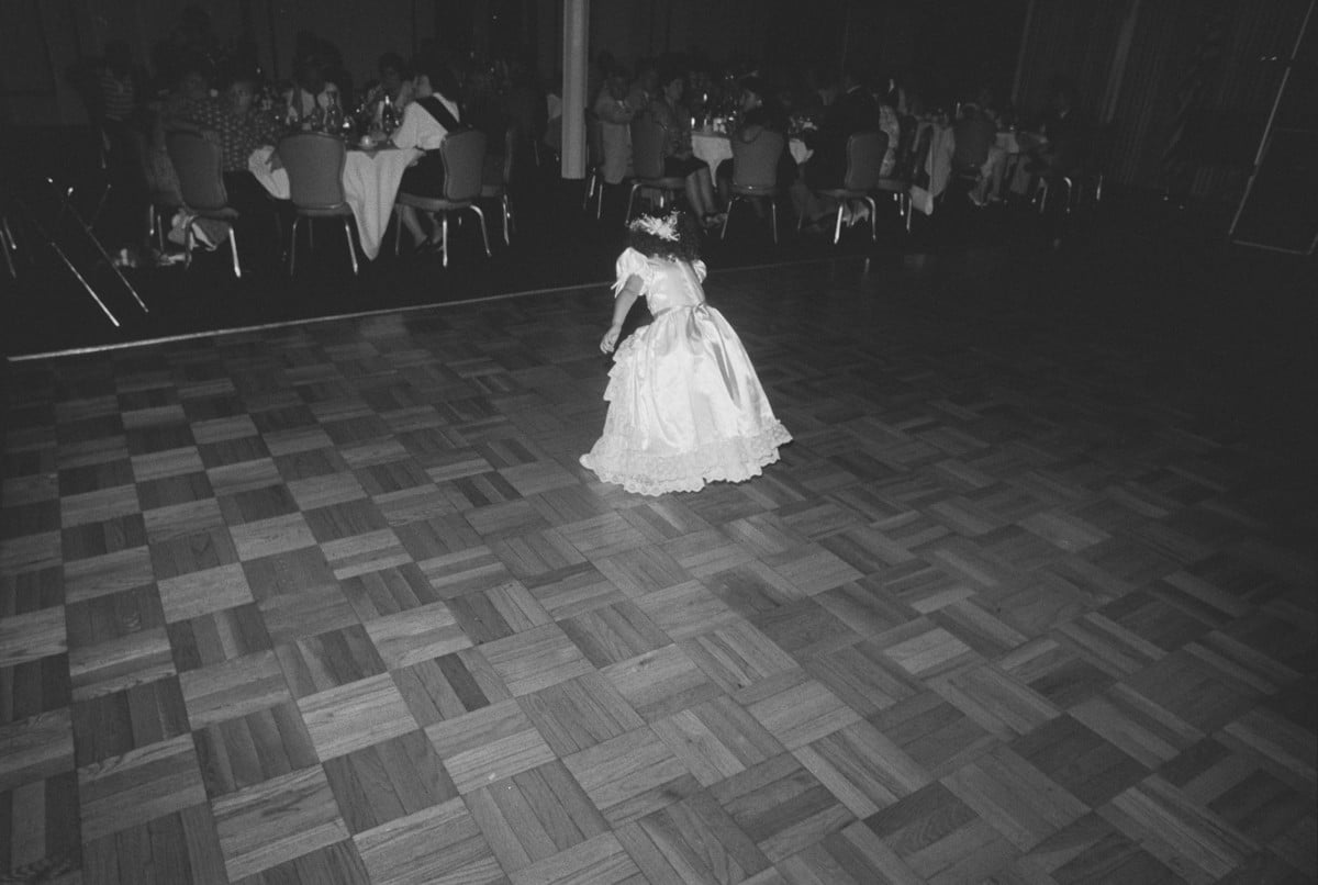 The flower girl in her lace dress on the dance floor at a 1989 wedding reception